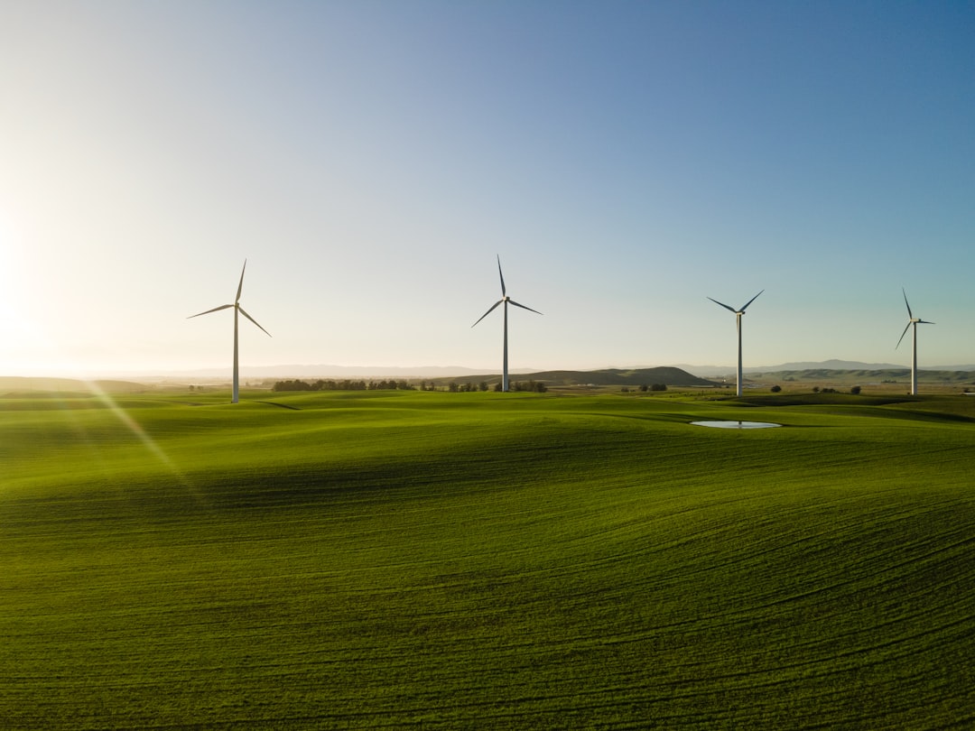 a-group-of-wind-turbines-in-a-green-field-ztbmpmgb-7a